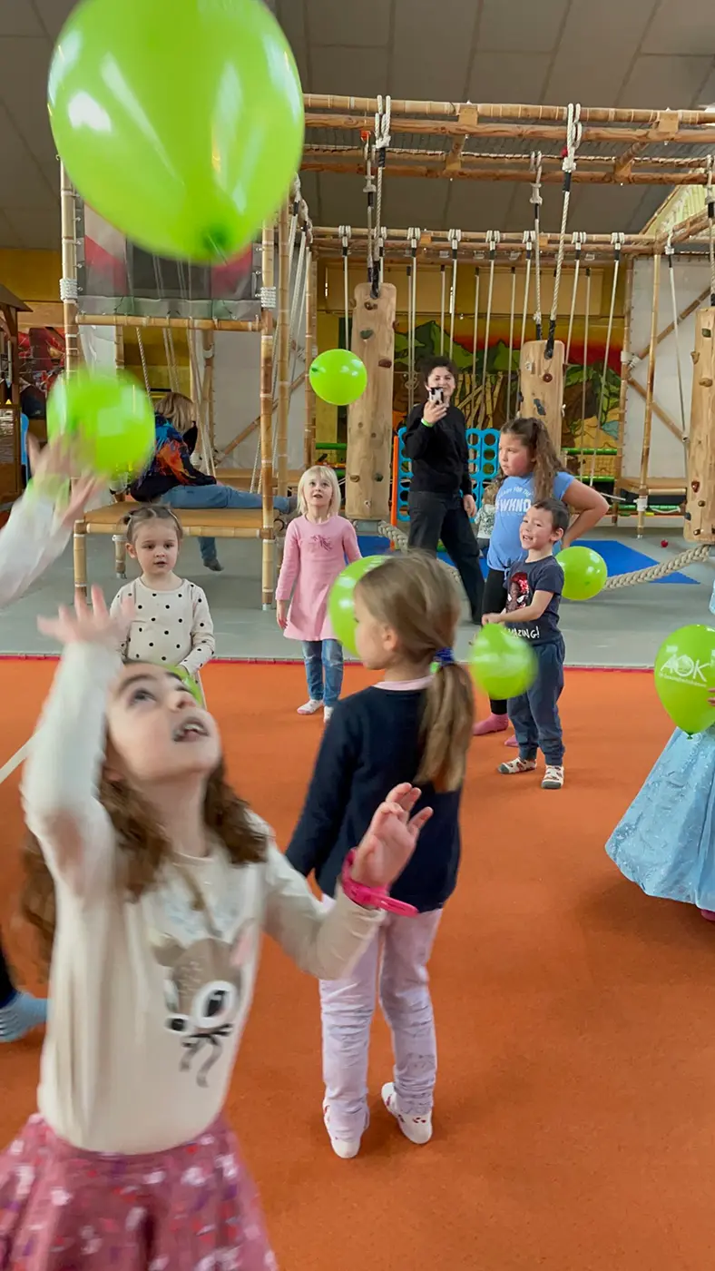 Kinder spielen mit Luftballons